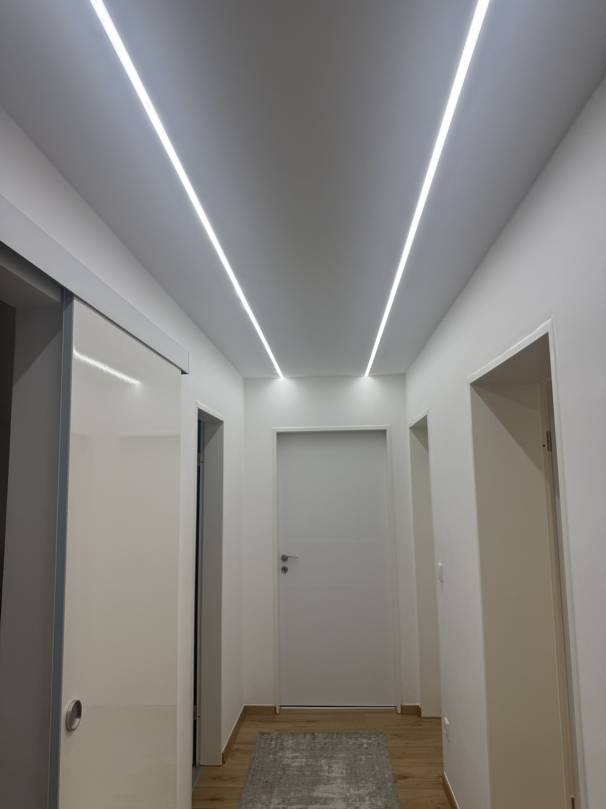 Fertiger Flur mit abgehängter Trockenbaudecke und LED-Lichtlinien in Waldkraiburg – E.K. Renovierung